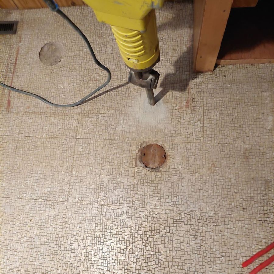 Breaking through a basement floor to reach the main sewer during a backwater valve install