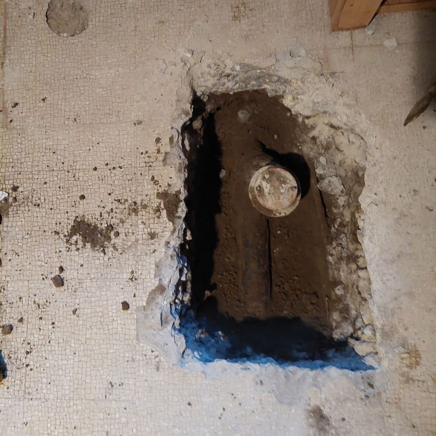 The main sewer exposed in the opened floor, ready for the backwater valve