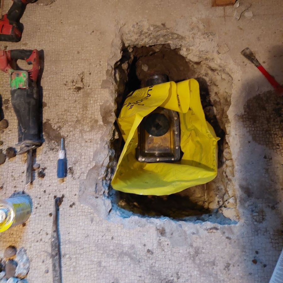 The backwater valve installed in the sewer line, wrapped for protection before new concrete is poured