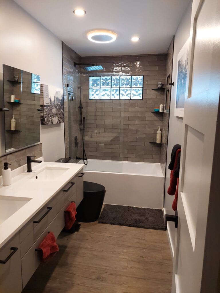 Bathroom renovation by EVCO with a double vanity and tiled tub and shower